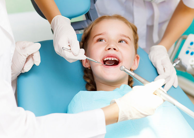 dentist checks a little girl's mouth